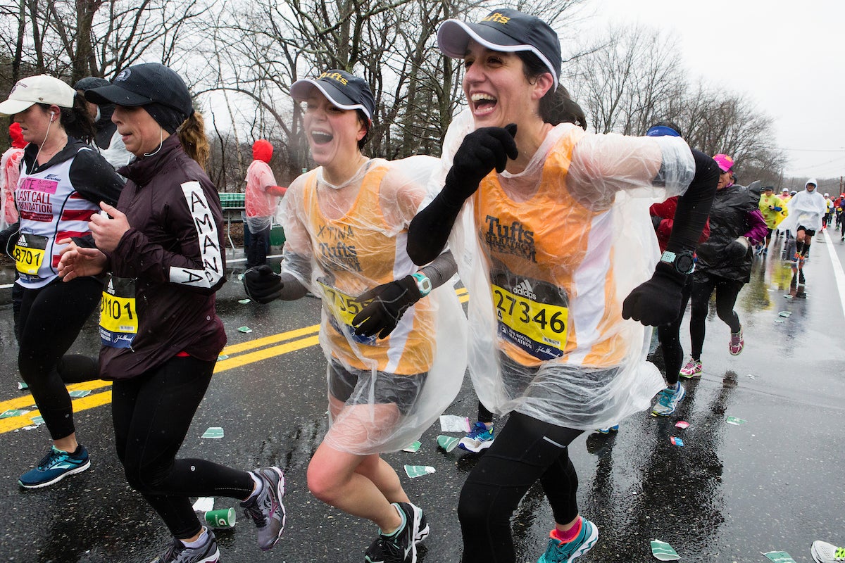 people running in the rain at the boston marathon