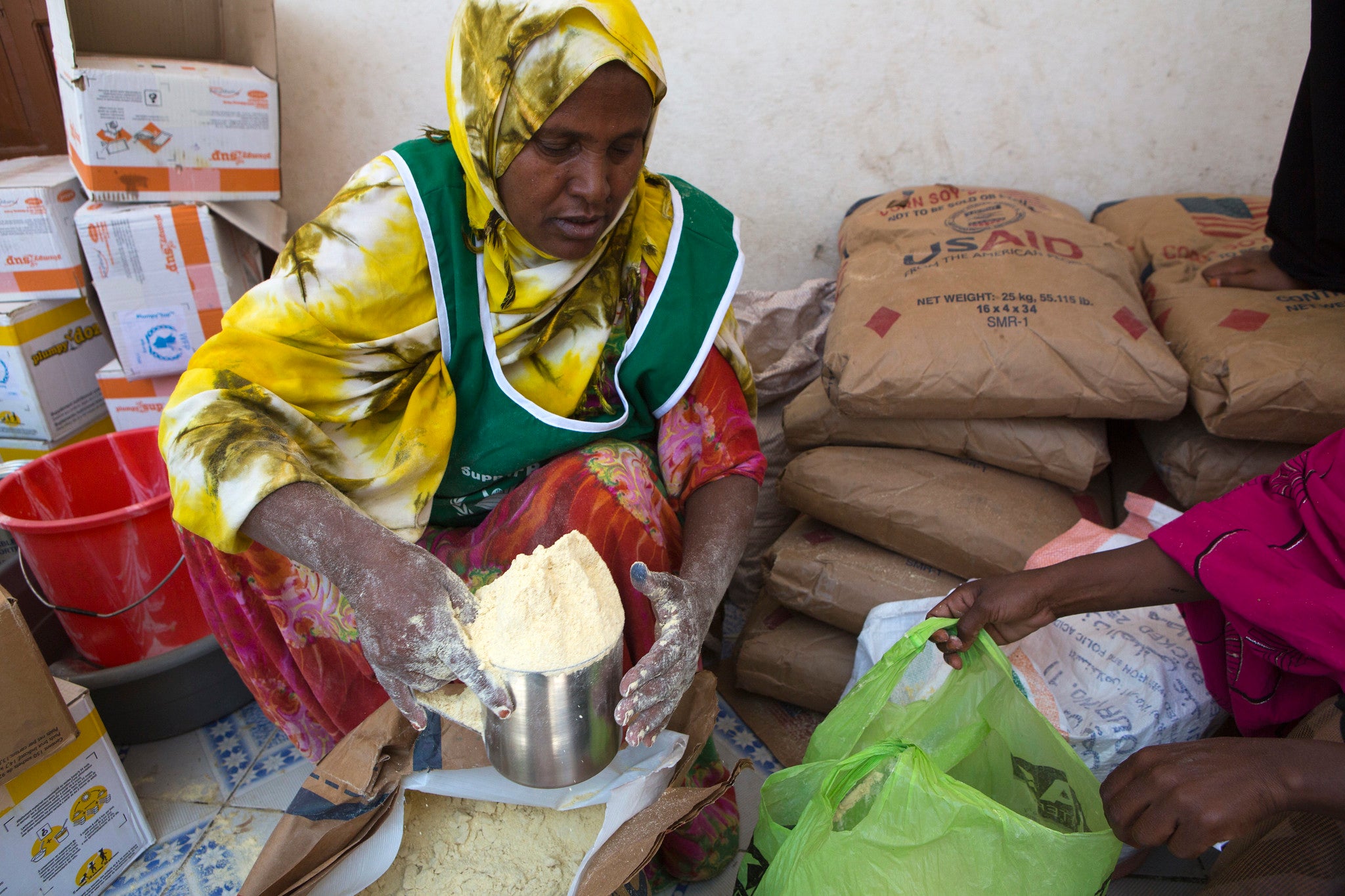 Photo showing an internally displaced woman in Somalia receiving food (Photo Credit: USAID)